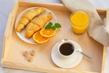 Breakfast in bed with coffee, croissants and juice