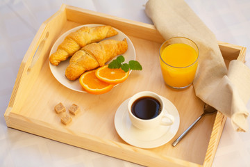 Breakfast in bed with coffee, croissants and juice