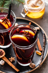 Hot mulled wine with spices, apple and orange on chrictmas background. Copy space.
