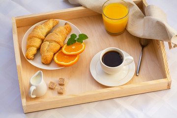 Breakfast in bed with coffee, croissants and juice