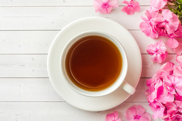 Pink Phlox flowers and a Cup of coffee on a white table. Free space for text
