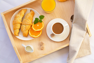 Breakfast in bed with coffee, croissants and juice
