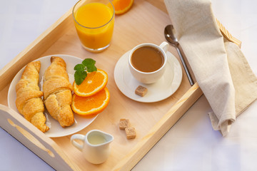 Breakfast in bed with coffee, croissants and juice