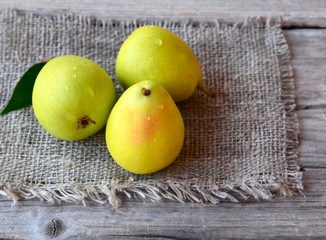 Fresh ripe organic pears on a burlap cloth on old wooden table.Garden fruits harvest.Healthy...