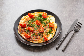 Omelet with tomatoes and herbs. Delicious breakfast
