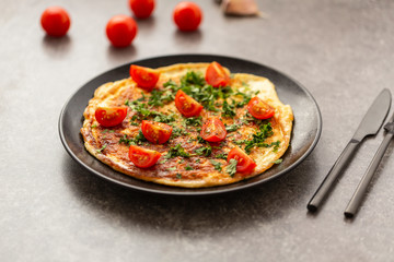 Omelet with tomatoes and herbs. Delicious breakfast
