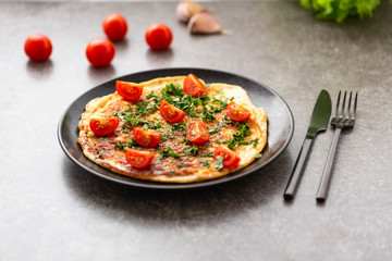 Omelet with tomatoes and herbs. Delicious breakfast