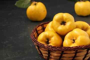 Ripe yellow quince fruit on dark background in a wicker basket, healthy lifestyle, nutrition Copy space