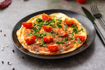 Omelet with tomatoes and herbs. Delicious breakfast