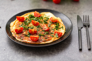 Omelet with tomatoes and herbs. Delicious breakfast