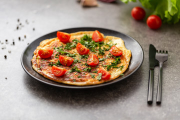 Omelet with tomatoes and herbs. Delicious breakfast