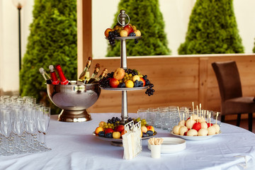 Fourchette buffet table for guests at the celebration, candy bar, fruit, champagne