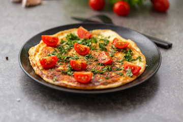 Omelet with tomatoes and herbs. Delicious breakfast