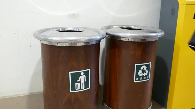 Motion of woman throwing trash to the garbage can inside shopping mall with 4k resolution.