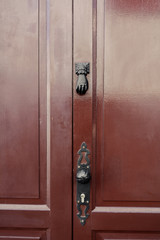 Drzwi z czarną ozdobną klamką i ozdobnym zamkiem