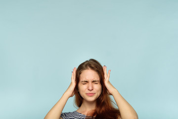 don't want to hear it. rejection refusal and denial. young woman covering ears with hands. portrait of a girl with tightly shut eyes on blue background. - obrazy, fototapety, plakaty