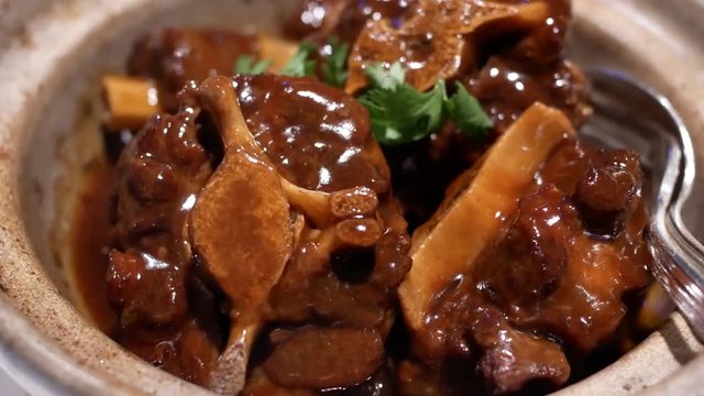 Motion of stewed oxtail and radish inside small pot at Chinese restaurant with 4k resolution.