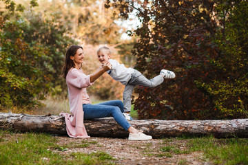 Happy family on autumn walk! Mother and son walking in the Park and enjoying the beautiful autumn nature.