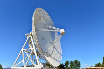 Array of satellite dishes or radio antennas against sky. Space o