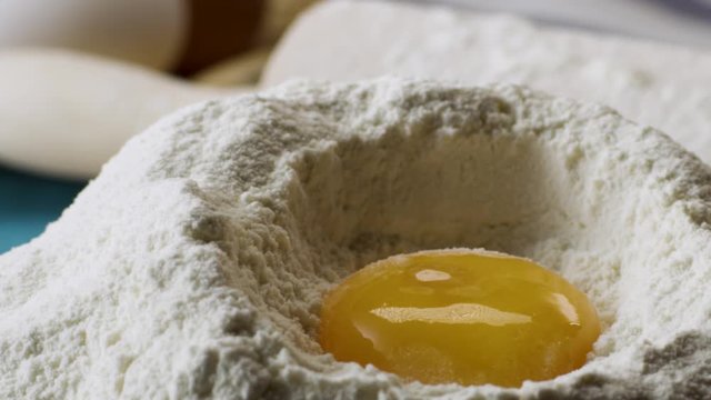 Yolk Falls Into the Flour in Slow motion, close up. Scene. Falling eggs into flour stock. Footage food. Egg dropping into flour, slow motion. Food Blog, Flour Products. Bakery products. Preparation of