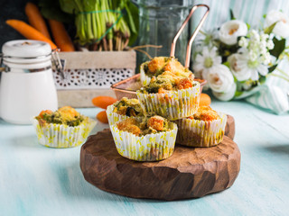 Home made healthy vegetable muffins with carrots and broccoli on wooden board. Corn breading