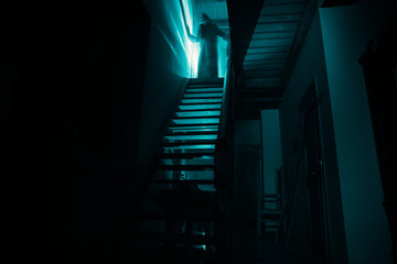 Inside of old creepy abandoned mansion. Staircase and colonnade. Silhouette of horror ghost...