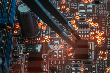 smd electronic components mounting. tweezers assemblinf electronic details on pcb.