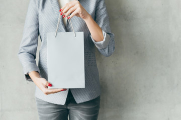 it's shopping time. woman holding white paper bag in hands. store sale concept.