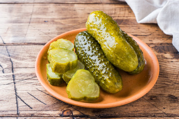 Pickled cucumbers in a wooden bowl dark rustic background