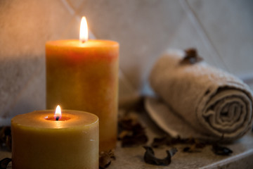 relaxing spa background with candles, some wooden petals and a towel