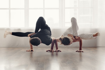 Two young people doing handstand with raised legs