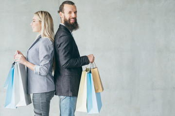 shopping therapy. happy couple delighted with new stuff they bought holding bags.