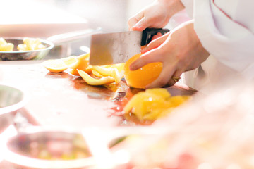 chef cutting orange
