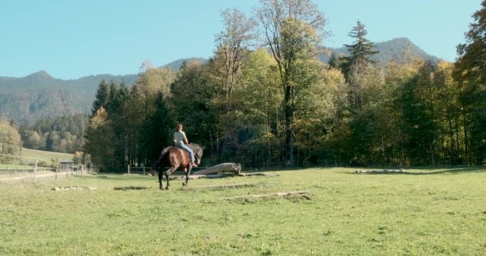 Junge Frau reitet auf gro&szlig;em schwarzen Pferd ohne Sattel 4k DCI 25p