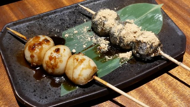 Motion of Japanese style grilled dango barbeque and sesame sauce on table inside Japanese restaurant with 4k resolution.