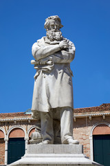 Fototapeta na wymiar Niccolo Tommaseo statue in Venice by Francesco Barzaghi (1839-1892) in a sunny summer day in Italy
