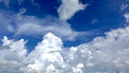 Dramatic deep blue sky with puffy white clouds in bright clear spring day times.     