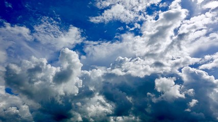 Dramatic deep blue sky with puffy white clouds in bright clear spring day times.     