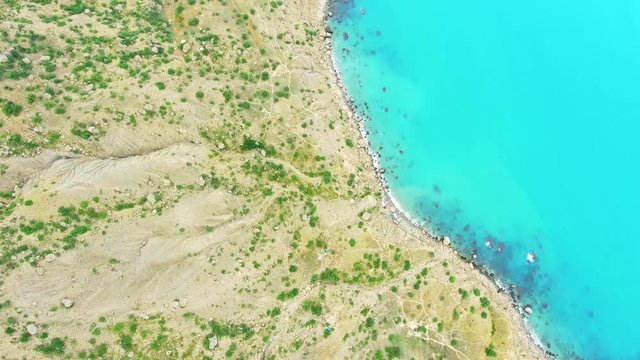 Aero view drone shot hills beach turqoise sea ocean and over green mountains Cape Point Megan islalnd Crimea, rocks by sea.