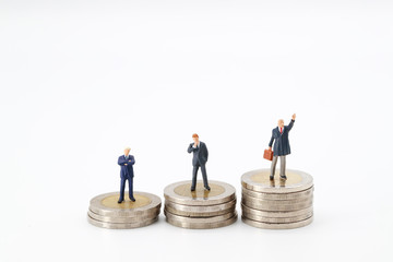 Miniature people: businessman standing on stacking coins , Financial and Business competition concept using as background.