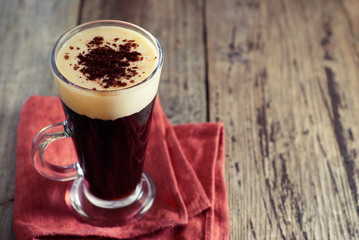 Espresso coffee. Espresso drink with cream, topped with whipped cream. Rustic wooden background.