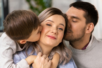 Fototapeta premium family, portrait and people concept - happy little son and father kissing mother at home