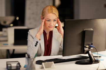 business, deadline and technology concept - businesswoman with computer working at night office