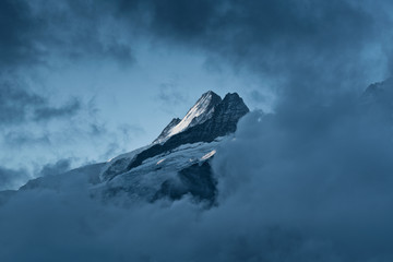 Summit Nässihorn at Grindelwald with glacier and snow in strong contrast framed by clouds