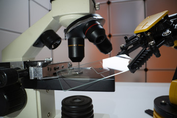 Fototapeta na wymiar Microscope slide in robot arm and science microscope