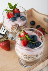 Healthy breakfast, oat meal with fruits: bluebery, strawbery and min, parfait in a glass on a rustic wooden background. Healthy food.