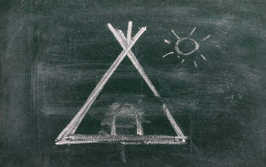 Native american tipi tent drawn on chalkboard, blackboard background and texture