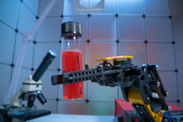 Test tube in robot arm. robot manipulates chemical tubes in the laboratory