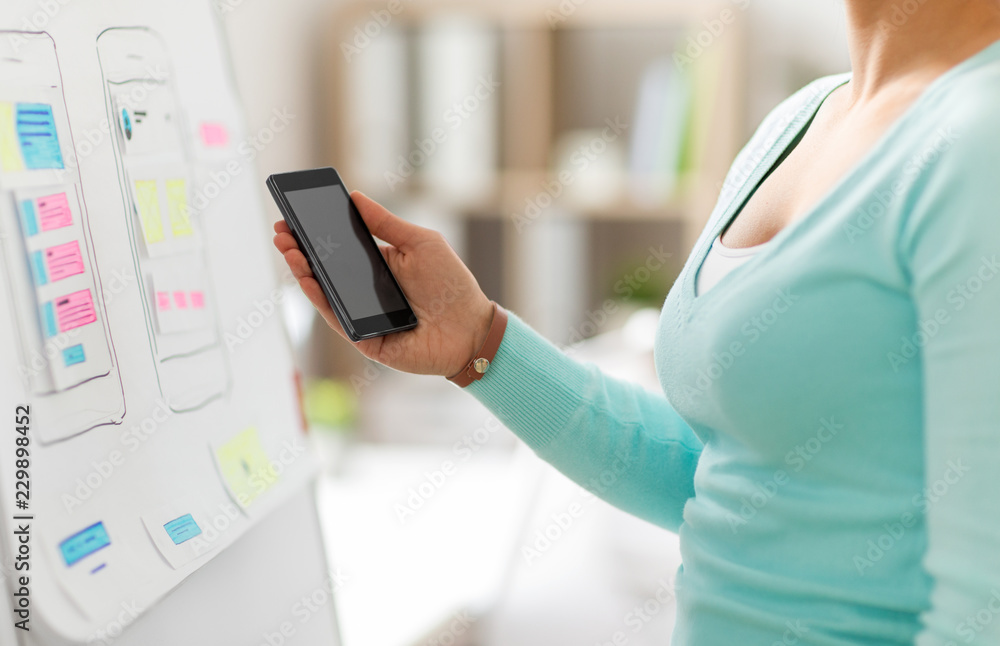 Aufkleber technology, user interface design and people concept - hand of ui designer or developer holding smar
