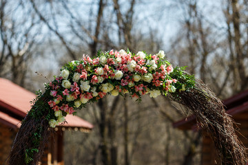 round wedding arch from branches decorated with flowers and decor around it